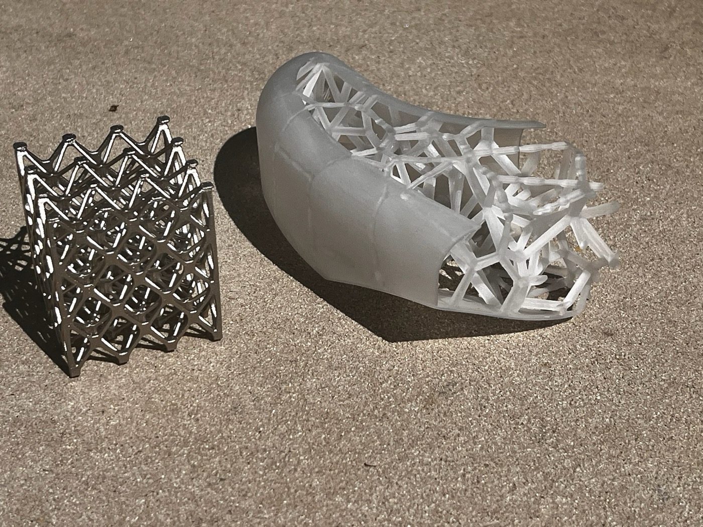 Two resin test pieces: a lattice swatch and a body horn section