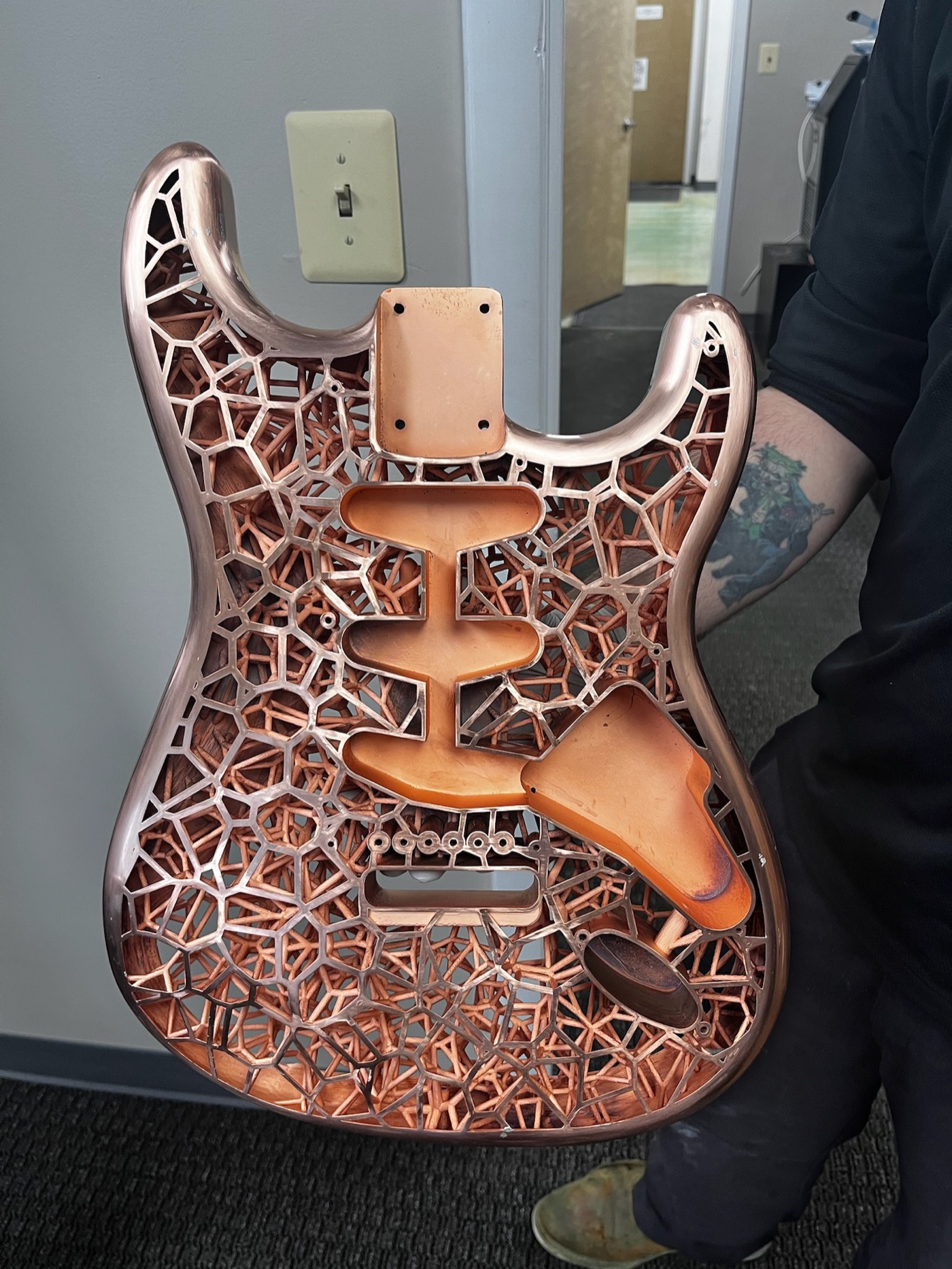 Copper electroplated Stratocaster body, front view, held with white gloves
