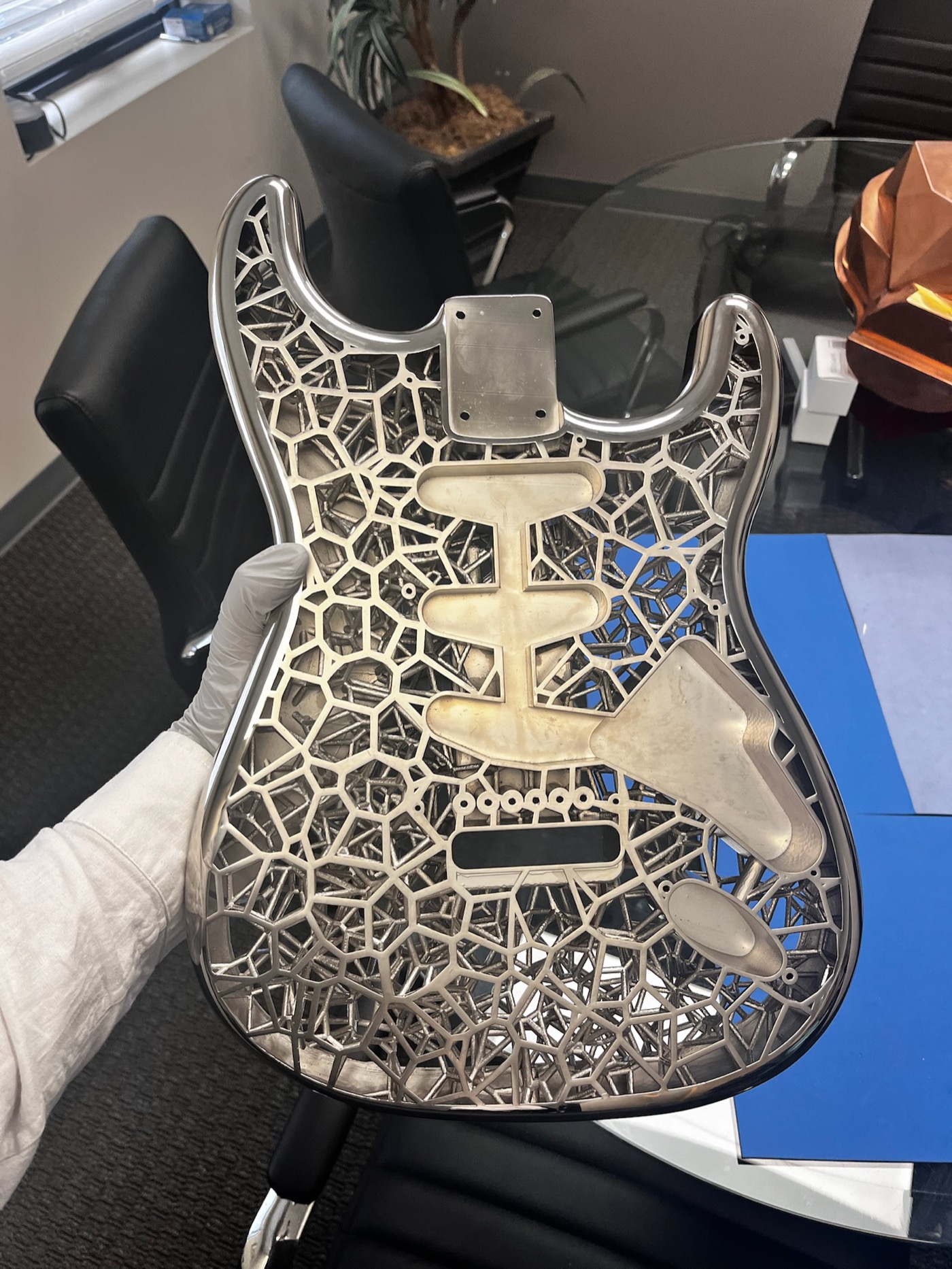 Nickel electroplated Stratocaster body held with white gloves, showing chrome-like finish