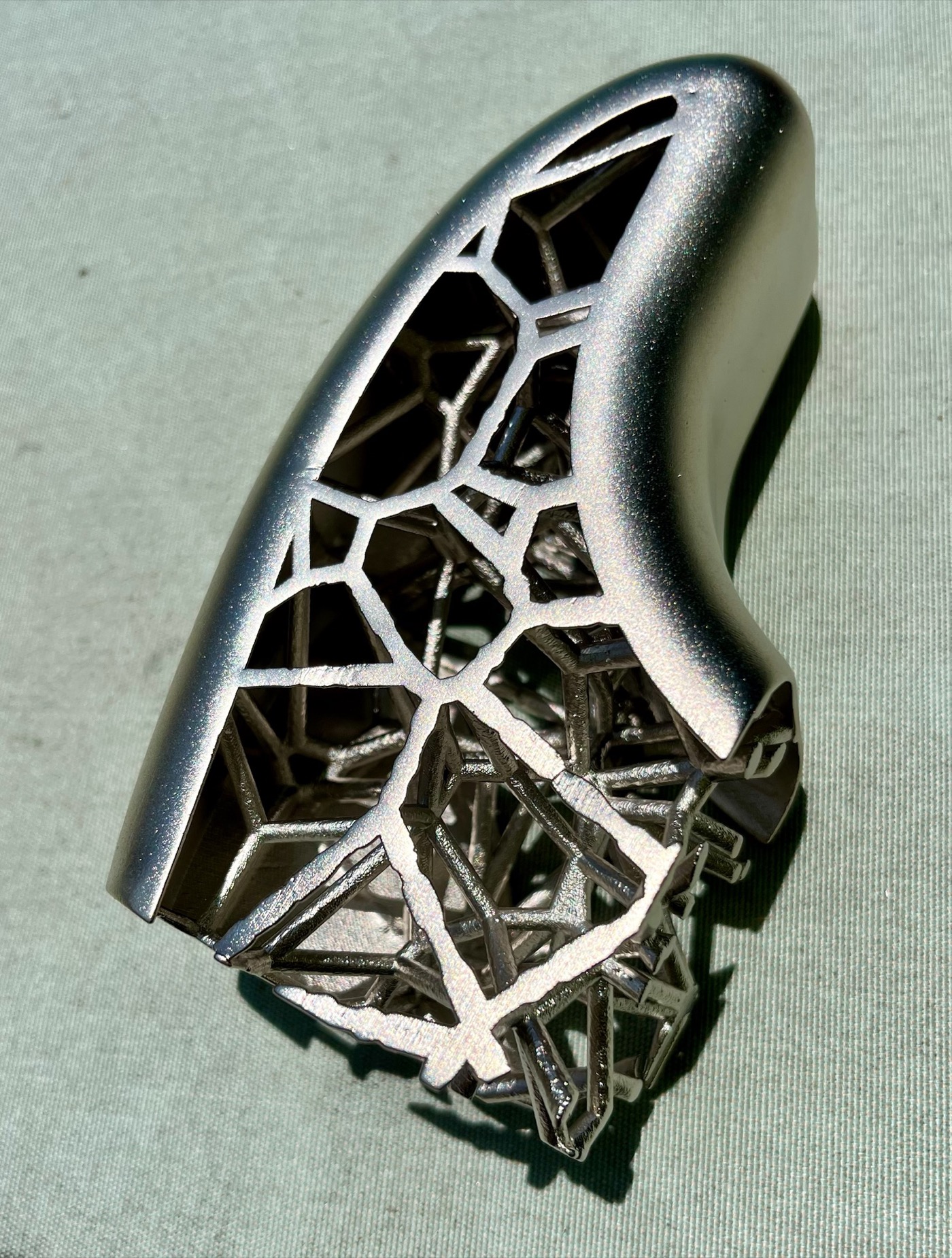 Close-up detail of the nickel-plated upper horn showing Voronoi lattice cell walls