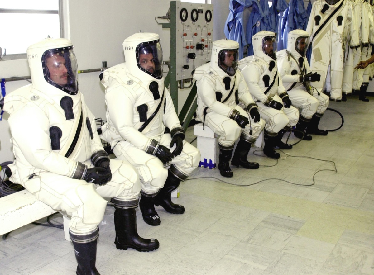 NASA technicians in SCAPE protective suits handling hypergolic propellants
